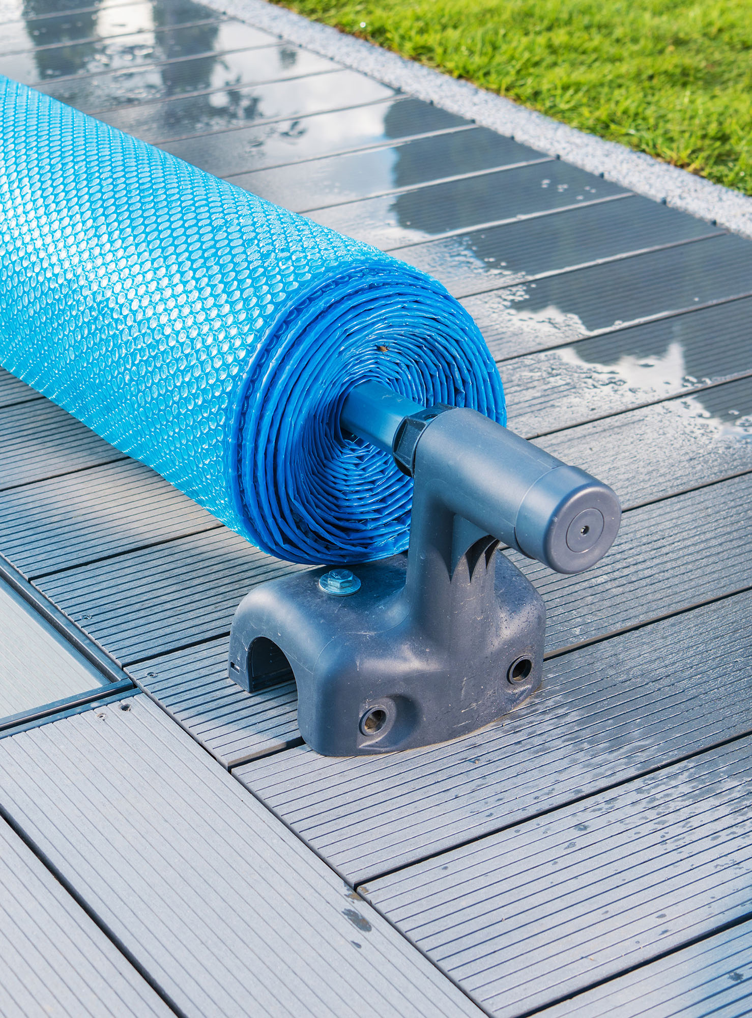 Manual Outdoor Swimming Pool Solar Blanket Cover Roller or Reel Close Up. Maintenance Water Temperature and Cleanliness.